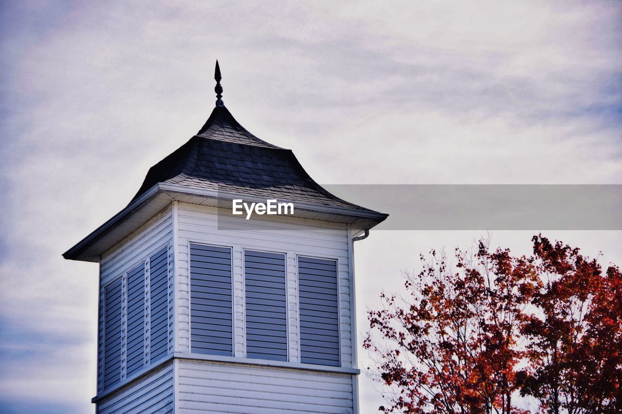 Low angle view of building against sky with autumn tree