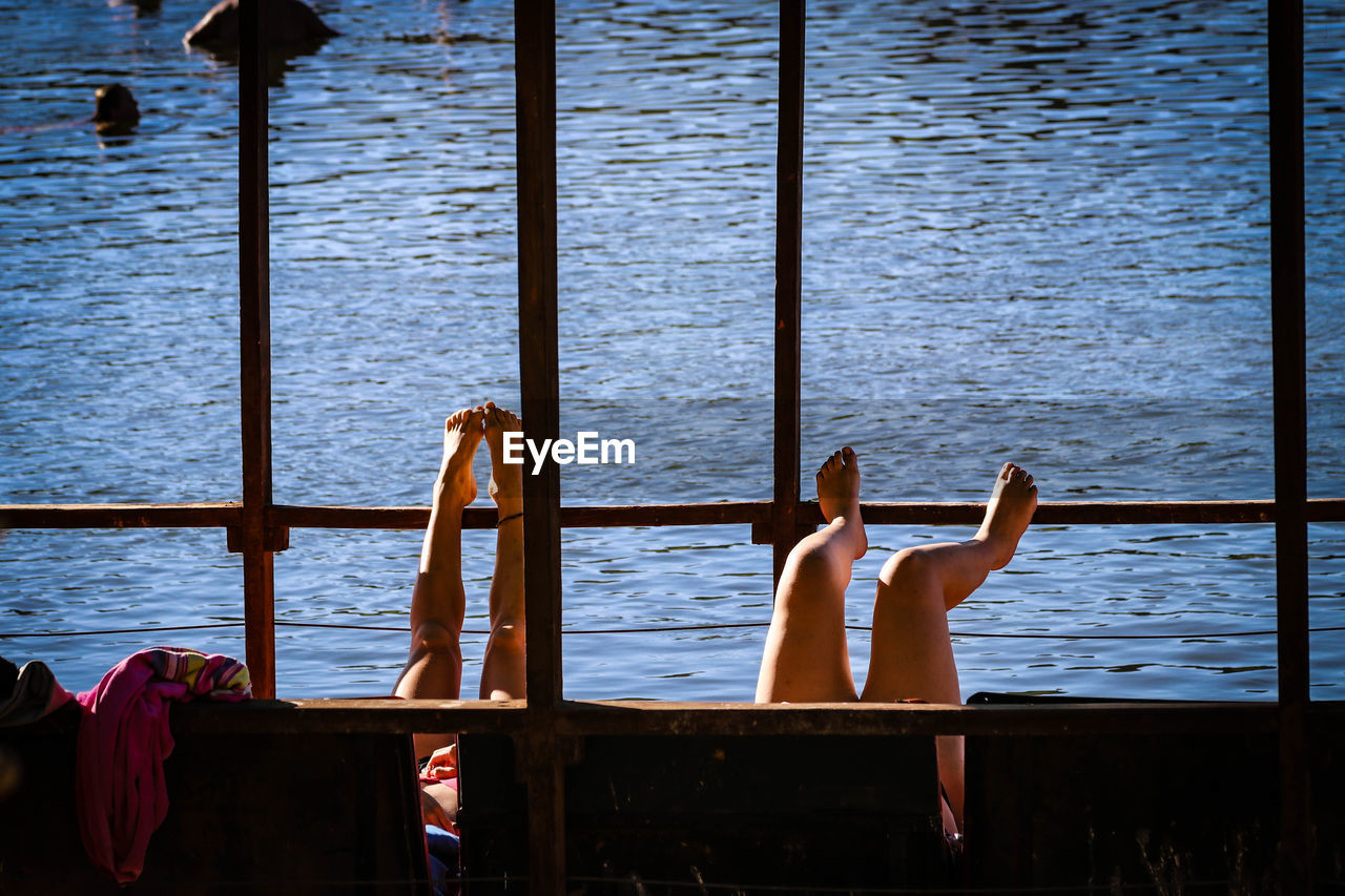 Low section of women relaxing at beach