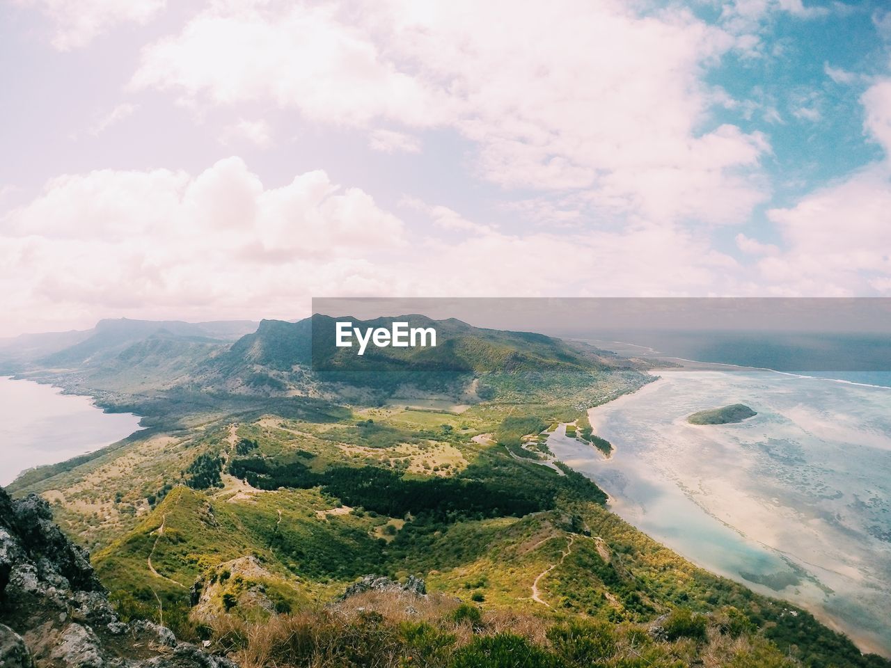 Scenic view of landscape by sea against sky