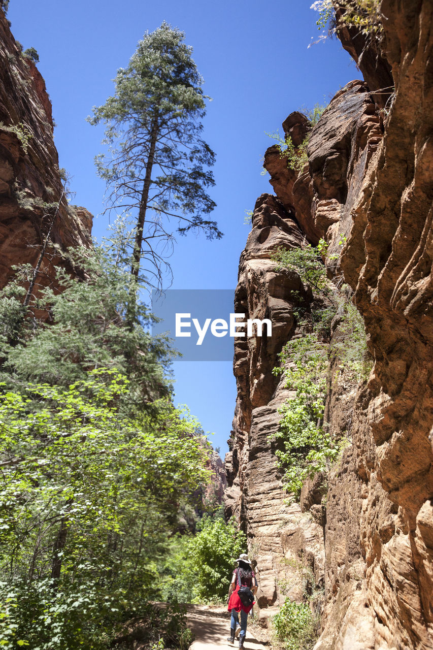 LOW ANGLE VIEW OF PEOPLE ON ROCK FORMATION