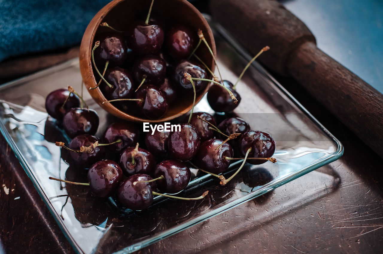 Close-up of cherry fruits in a wooden bowl on table