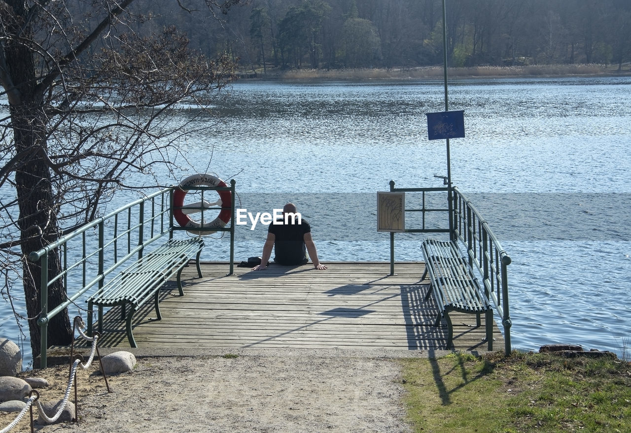 REAR VIEW OF MAN ON LAKE