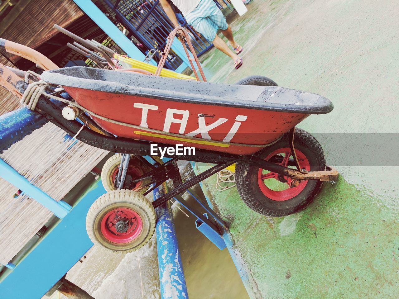 Wheelbarrow with text against man walking on road