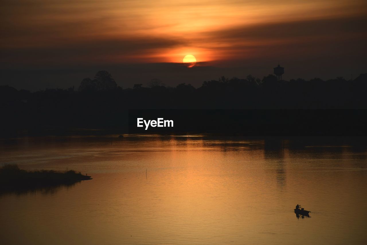 Scenic view of lake against orange sky