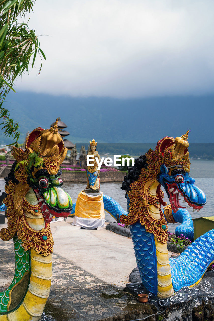 tradition, nature, water, sky, traditional clothing, person, clothing, day, outdoors, representation, full length, multi colored, religion, adult, belief, sculpture, arts culture and entertainment