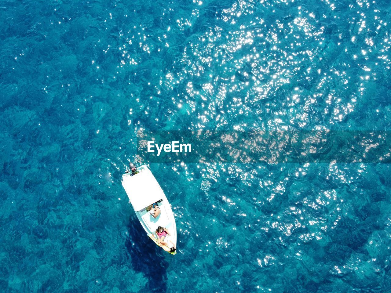 Aerial view of people relaxing on yacht in sea