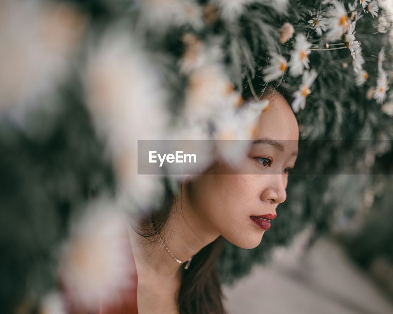 Close-up portrait of young woman amongst flowers