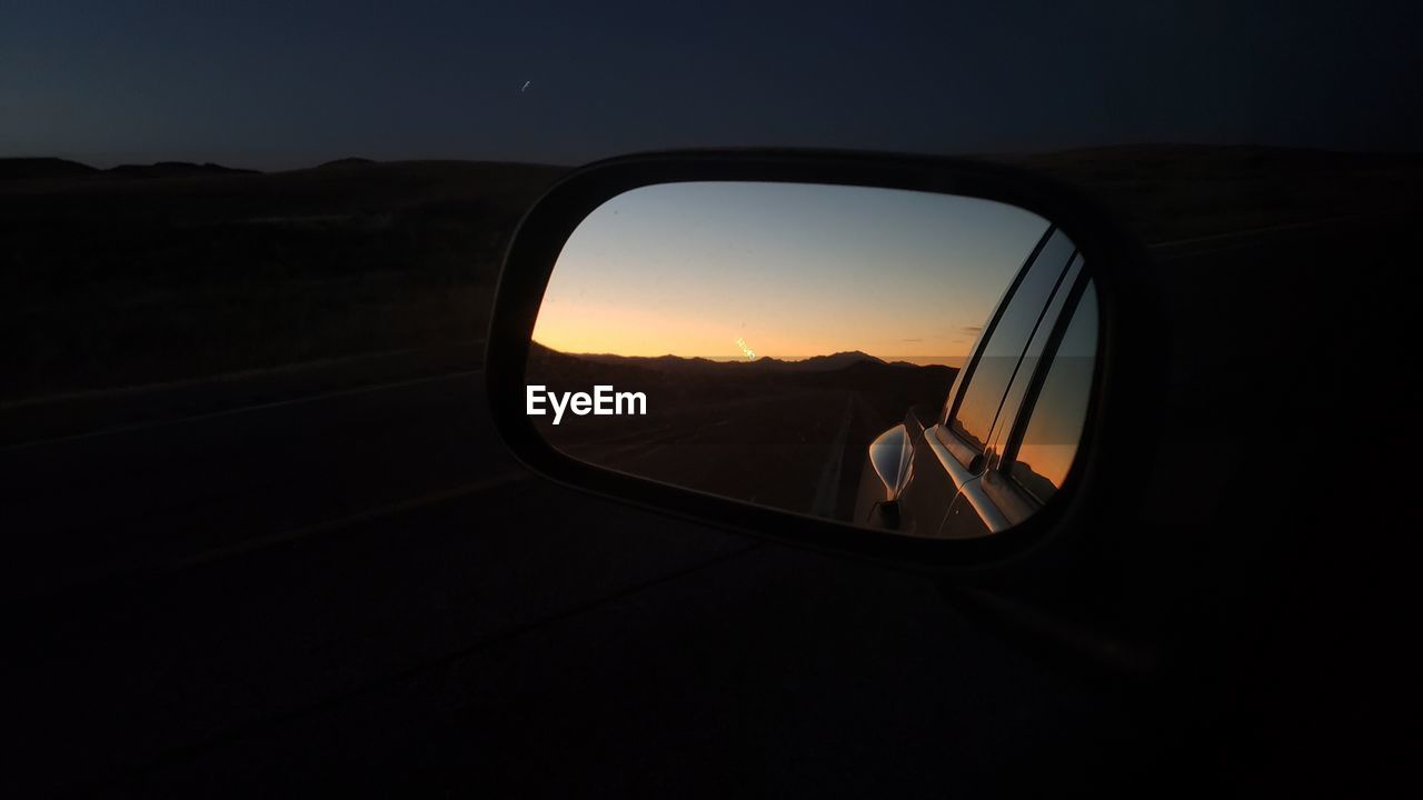 View of sunset in side view mirror