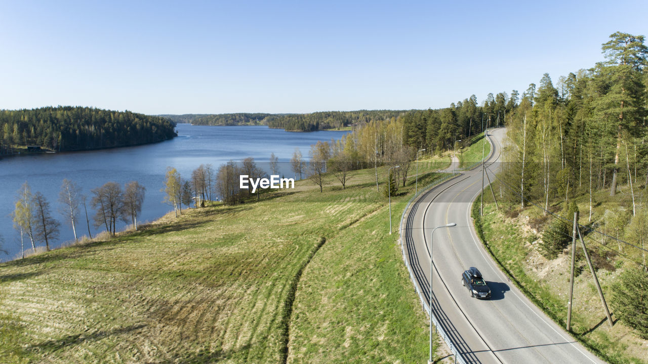 PANORAMIC VIEW OF ROAD BY LAKE AGAINST SKY