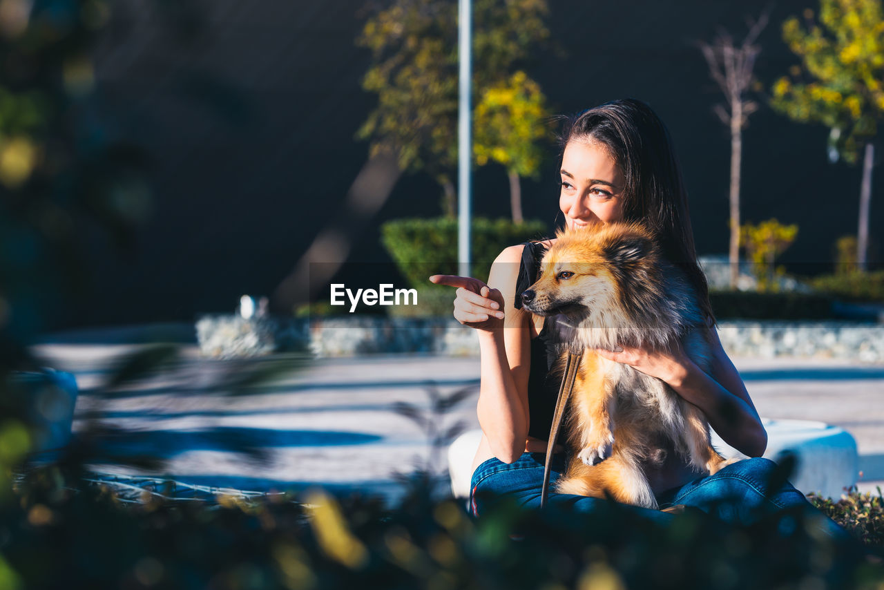 Woman with dog sitting at park