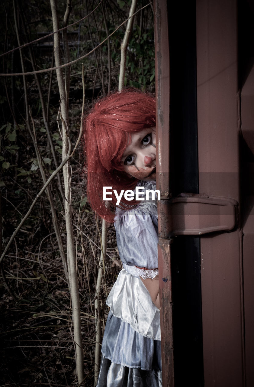 one person, darkness, spooky, women, redhead, clothing, portrait, fear, halloween, black, adult, horror, fashion, female, standing, goth subculture, three quarter length, nature, hairstyle, looking at camera, costume, plant, outdoors, young adult, celebration, dress, tree, mystery