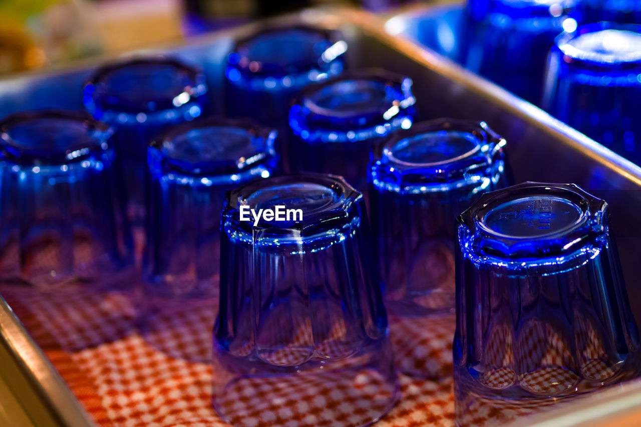 CLOSE-UP OF GLASSES ON TABLE AT NIGHT