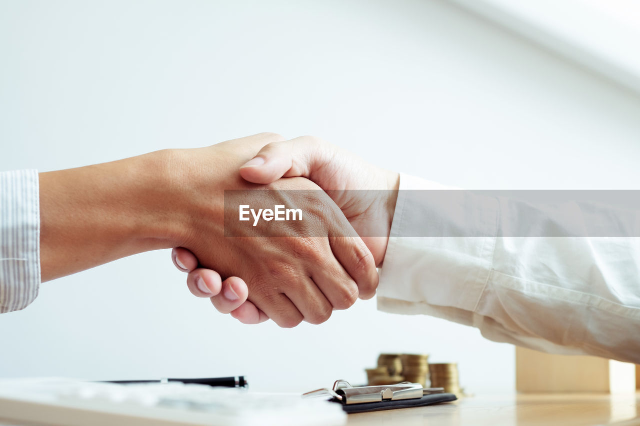 Agent and customer shaking hands at office