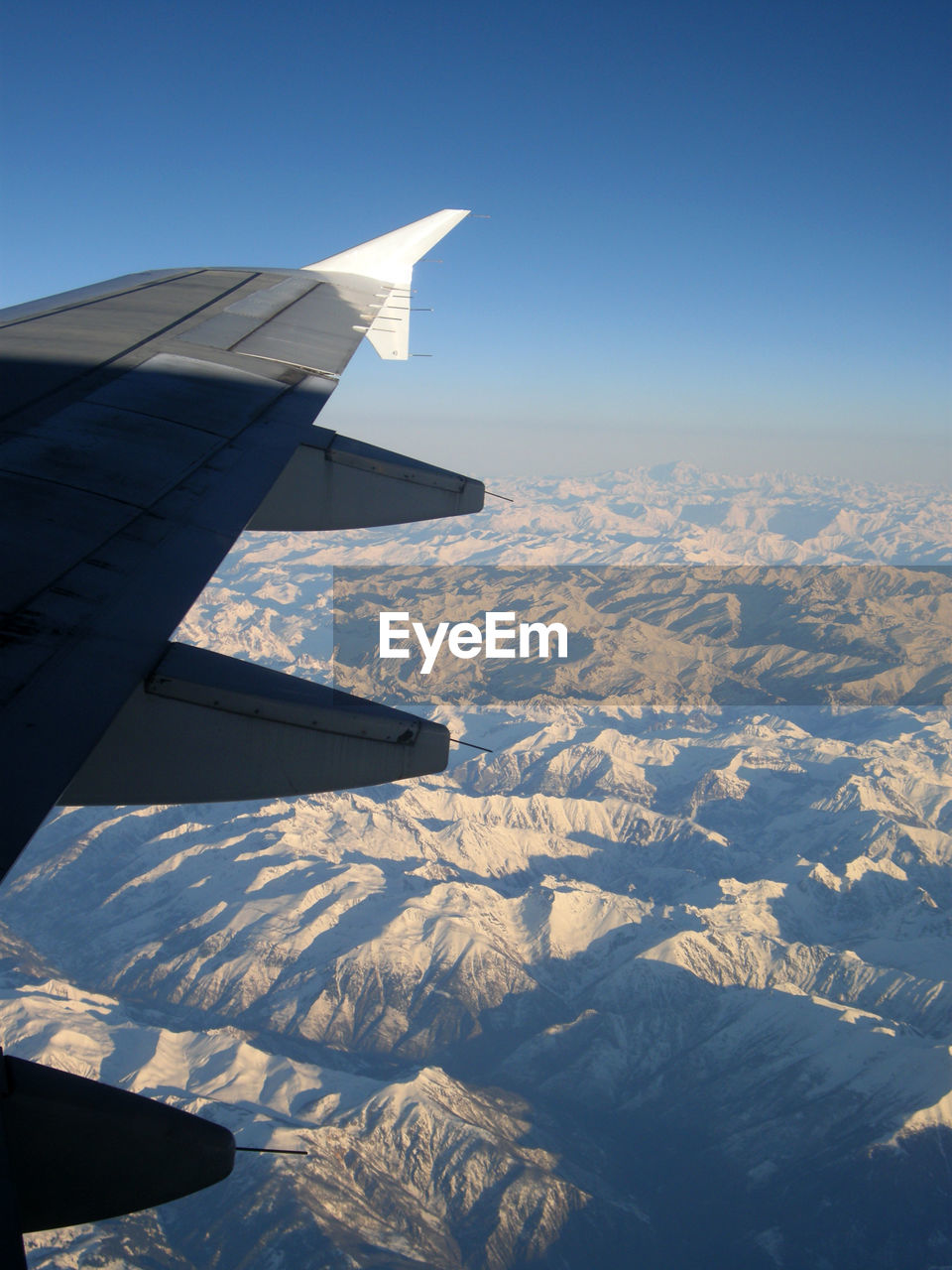 Cropped image of airplane wing over landscape