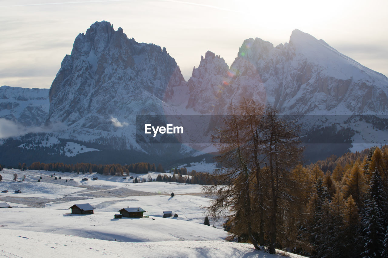 Scenic view of snow covered land and mountains against sky