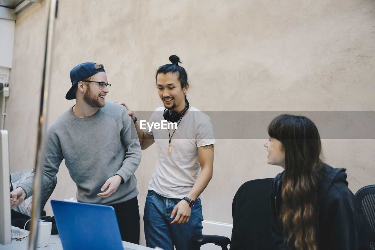 Happy male and female computer programmers in office