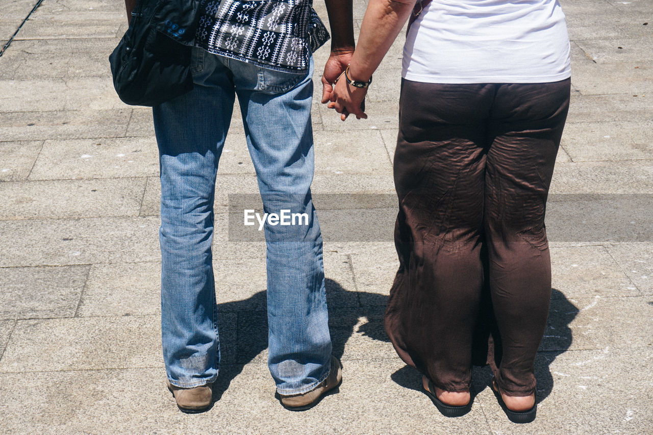 Low section of man and woman standing outdoors