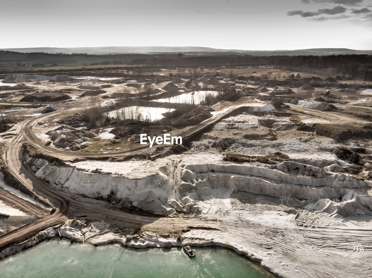 Aerial view of the edge of a large white sand quartz quarry, made with drone