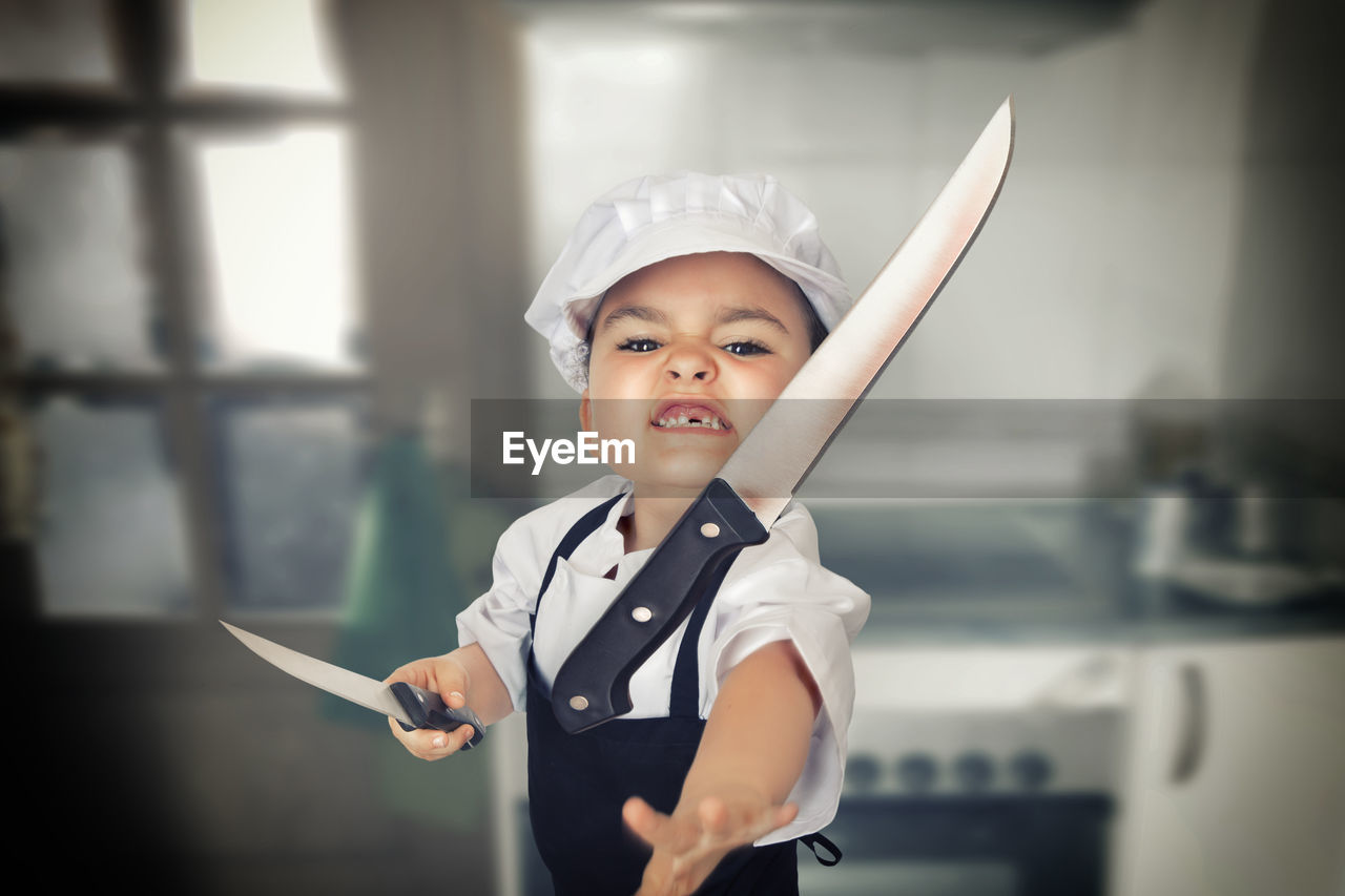 Close-up of angry boy throwing kitchen knife