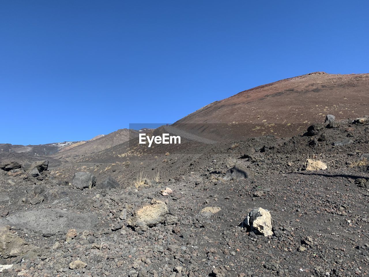 Scenic view of desert against clear blue sky