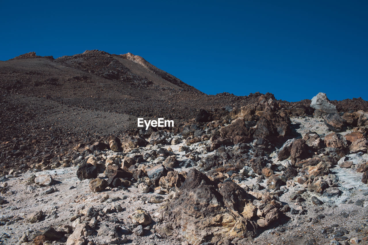 Scenic view of rocky mountains against clear blue sky