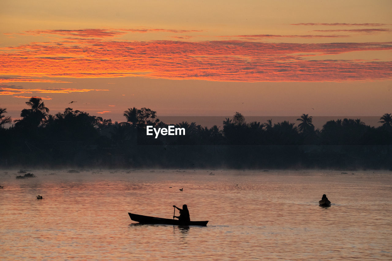 SILHOUETTE PEOPLE ON BOAT AGAINST SKY DURING SUNSET