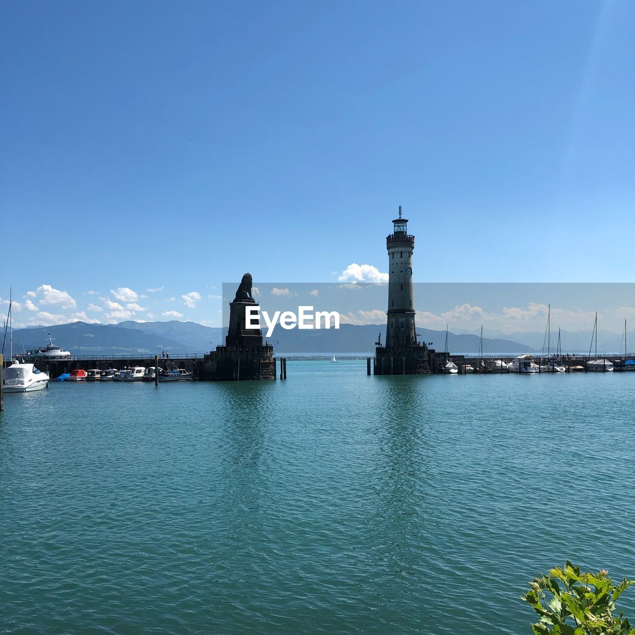 View of lighthouse at sea against blue sky