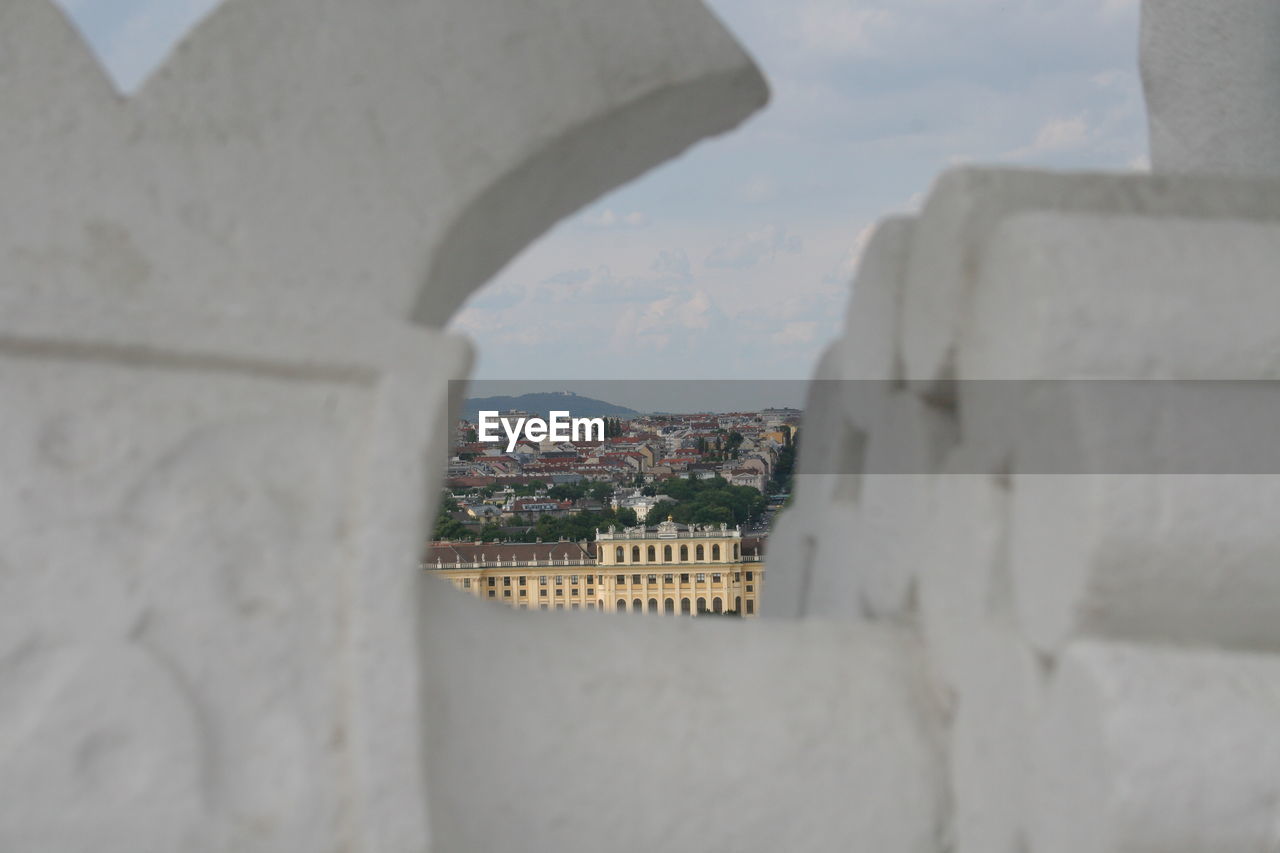 BUILDINGS AGAINST SKY SEEN THROUGH WALL