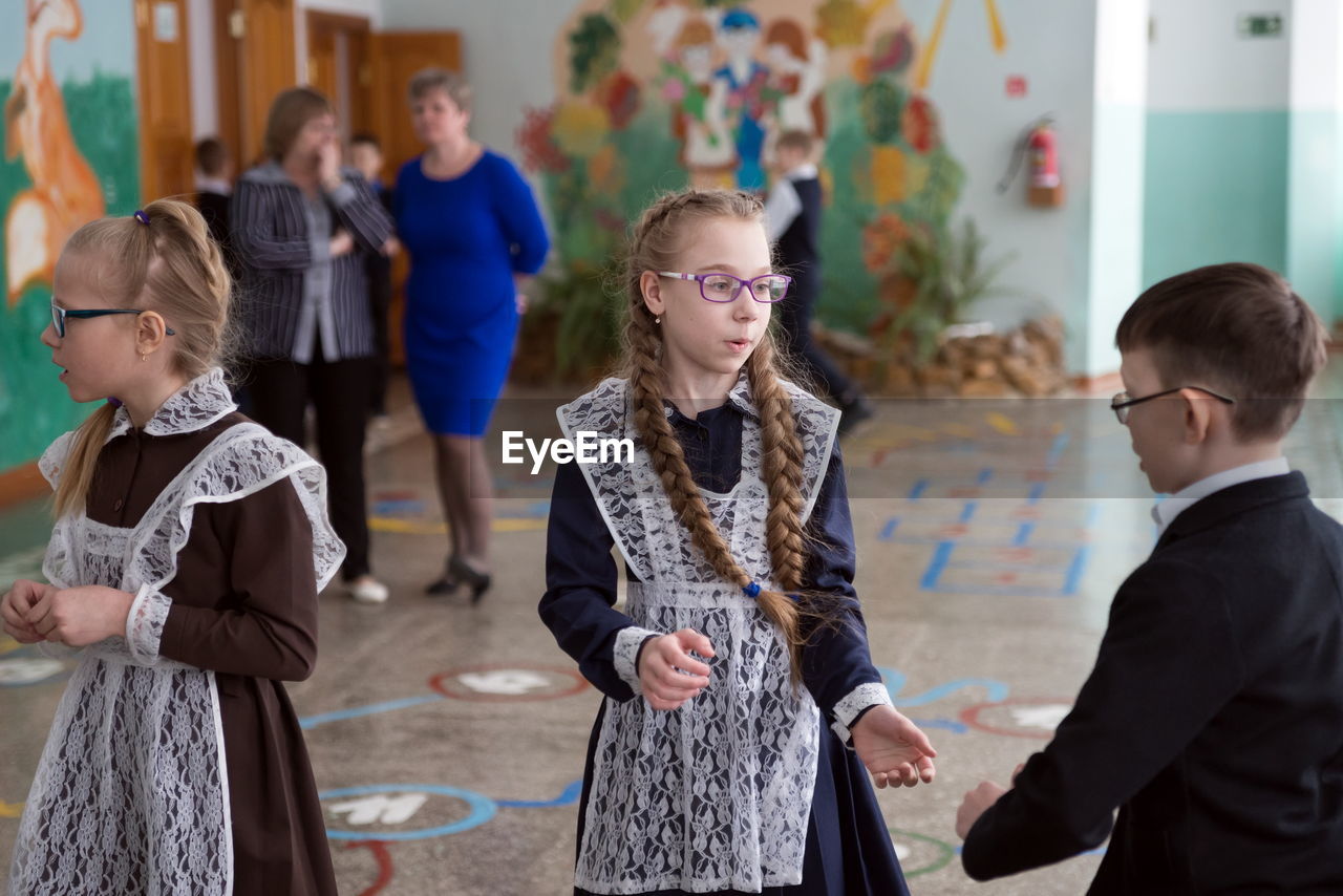 group of people, women, men, female, child, adult, childhood, indoors, standing, togetherness, three quarter length, eyeglasses, glasses, communication, business, focus on foreground, clothing, education, dress, teacher