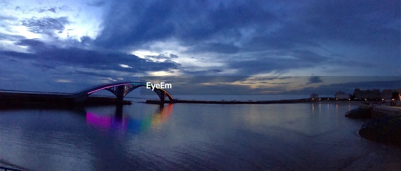 SILHOUETTE BRIDGE OVER SEA AGAINST SKY