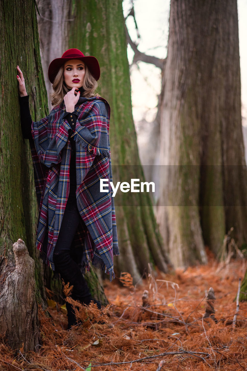 Full length of woman standing in forest