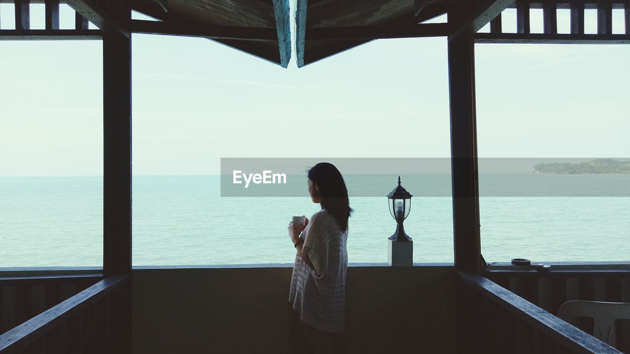 Woman looking at view while standing in boat deck