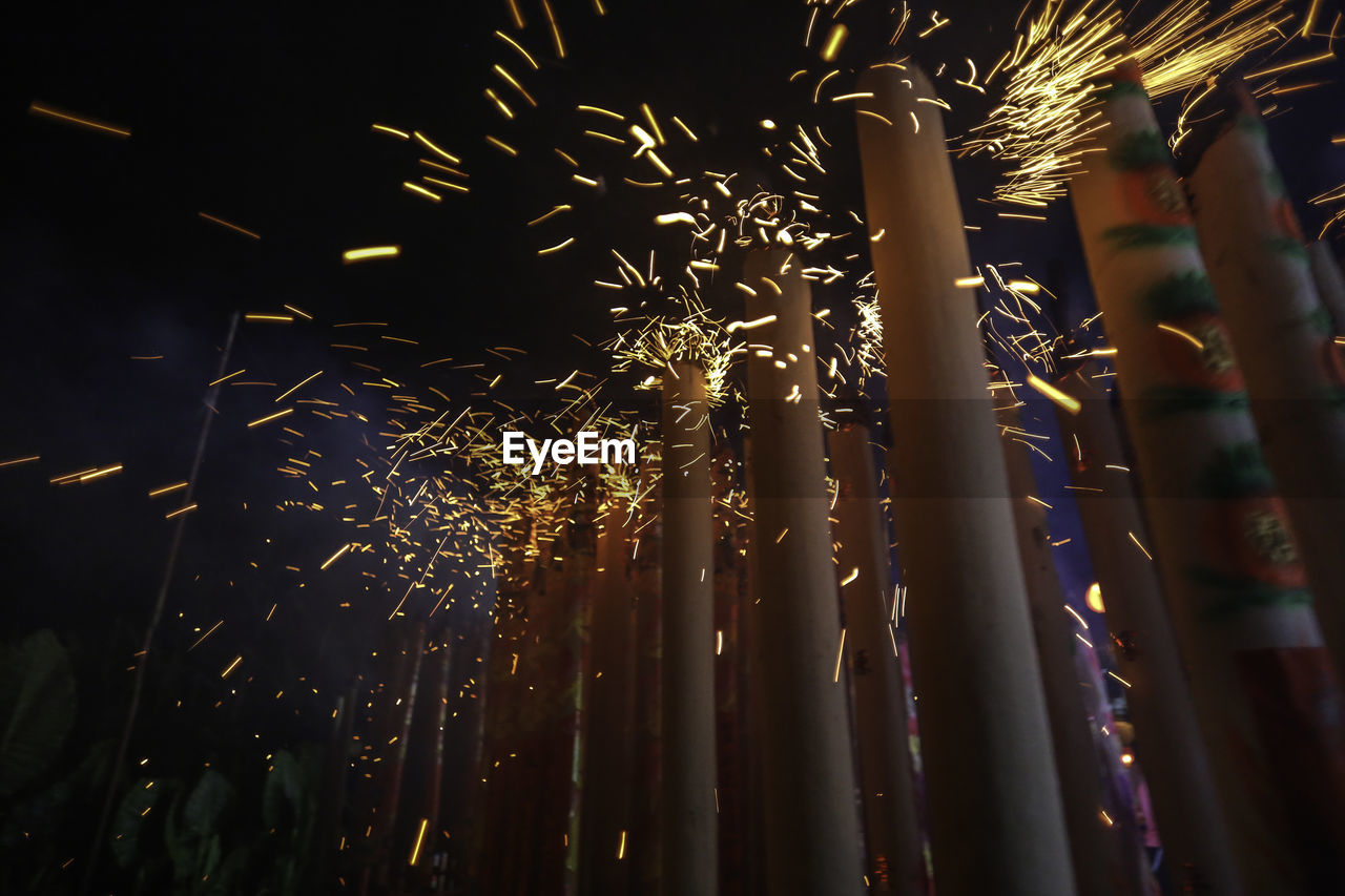 LOW ANGLE VIEW OF FIREWORKS DISPLAY AT NIGHT