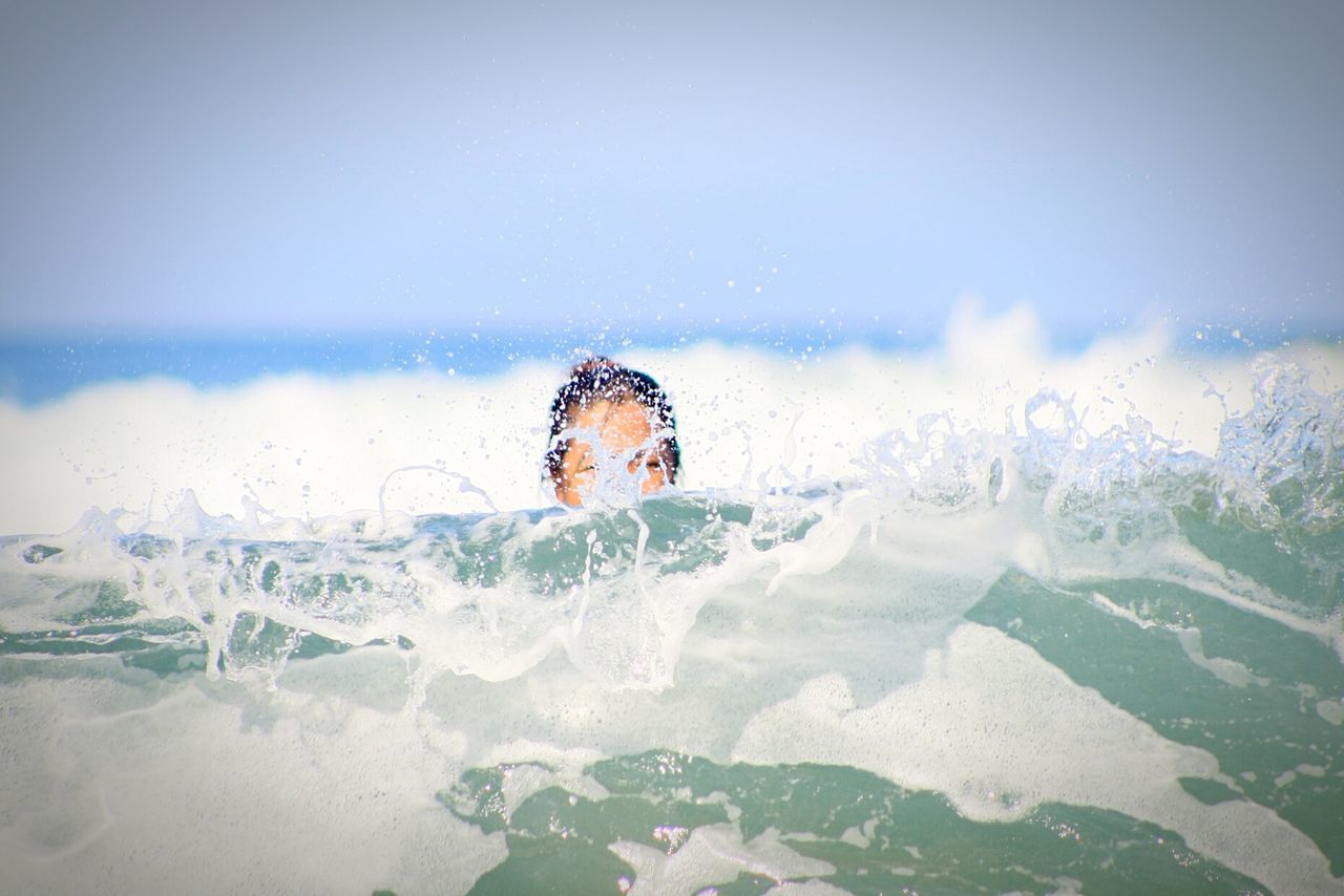 Woman swimming in sea against clear sky