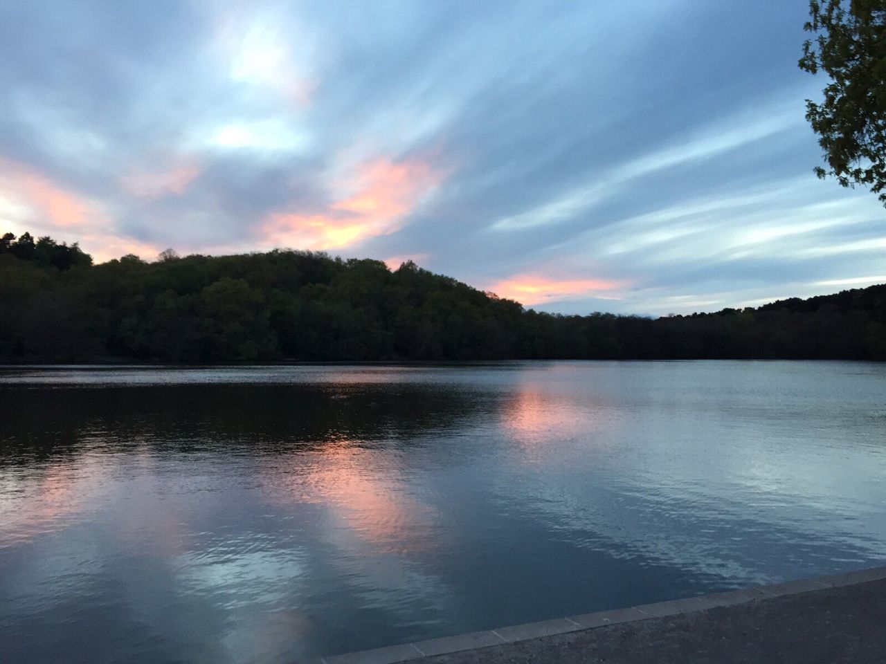 Scenic view of calm lake against cloudy sky