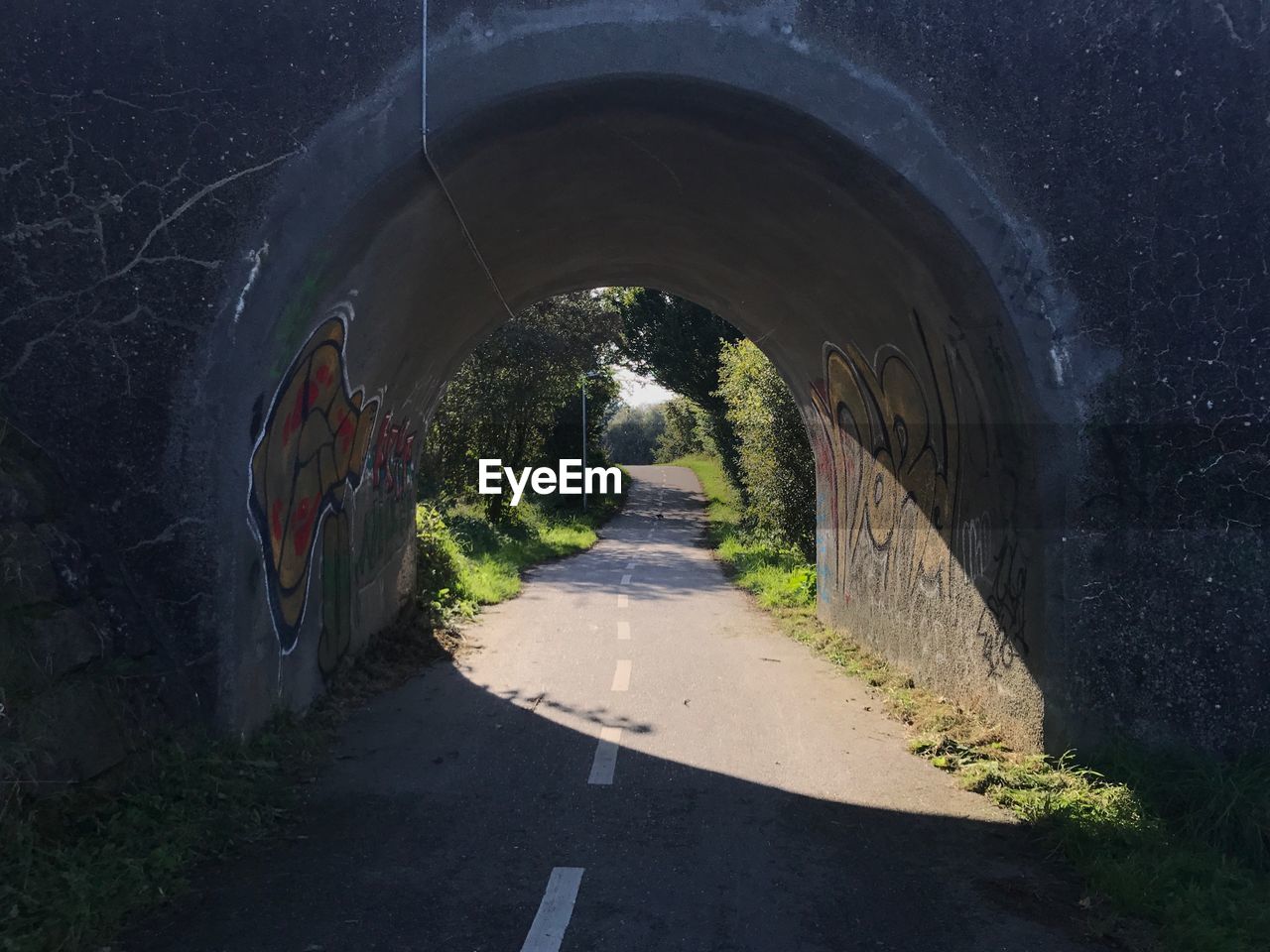 ROAD AMIDST TUNNEL AT NIGHT