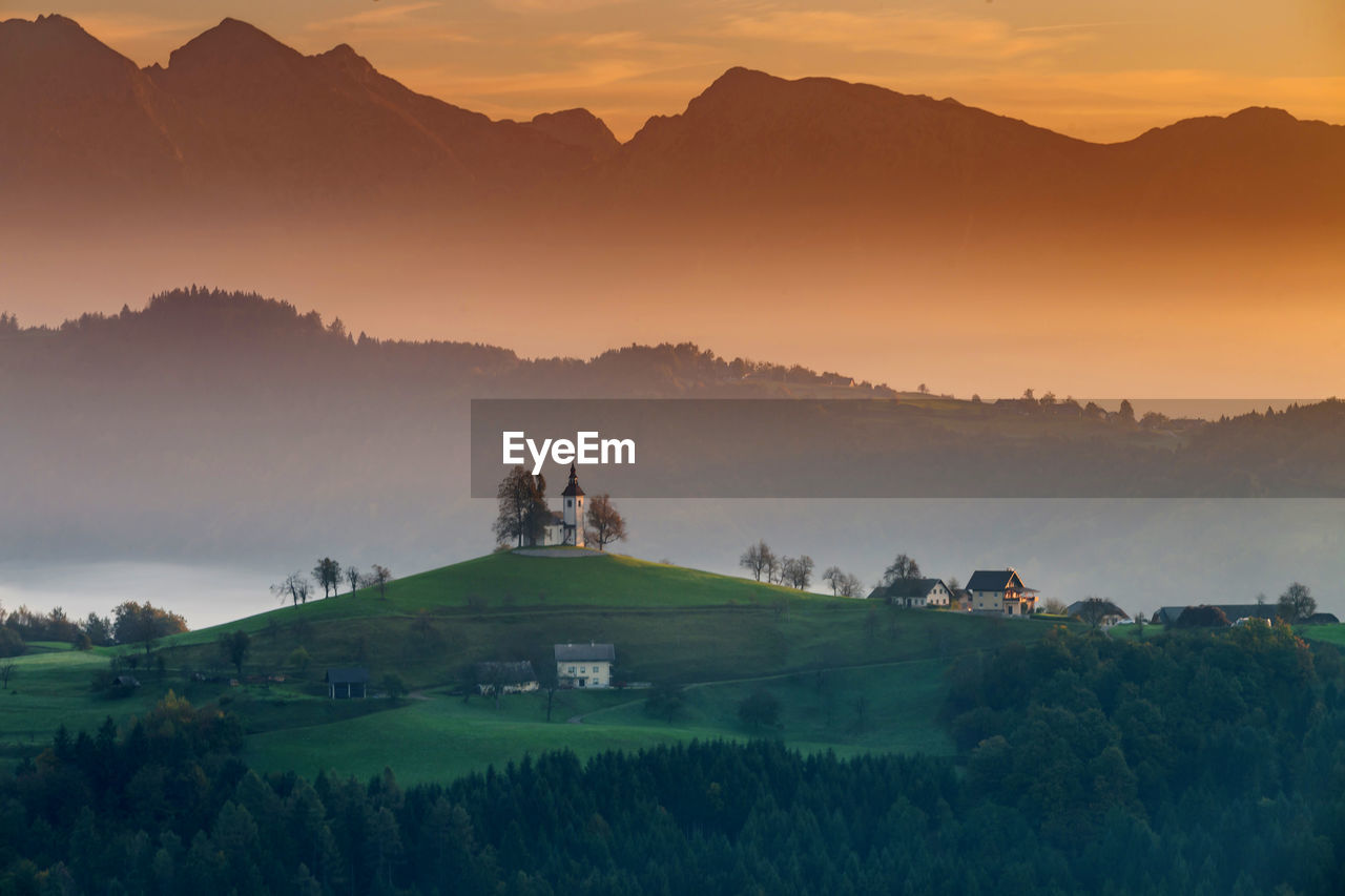 Scenic view of landscape against mountain during sunset