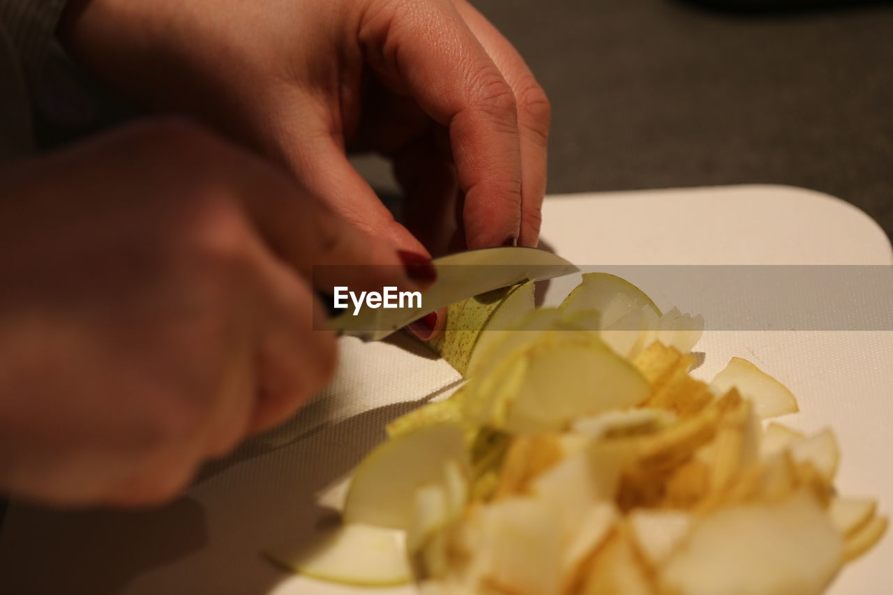 Cropped hands cutting food