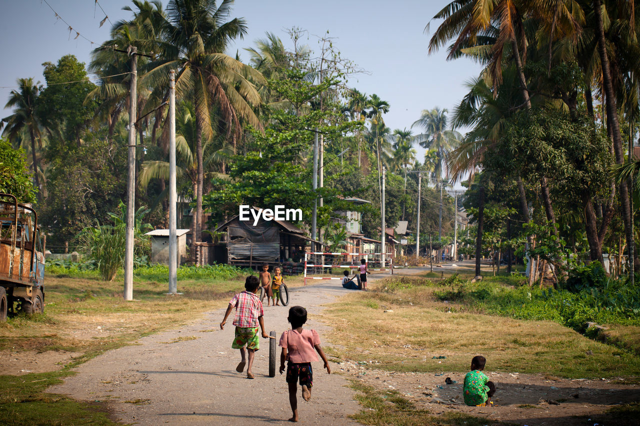 Children playing with tires on footpath