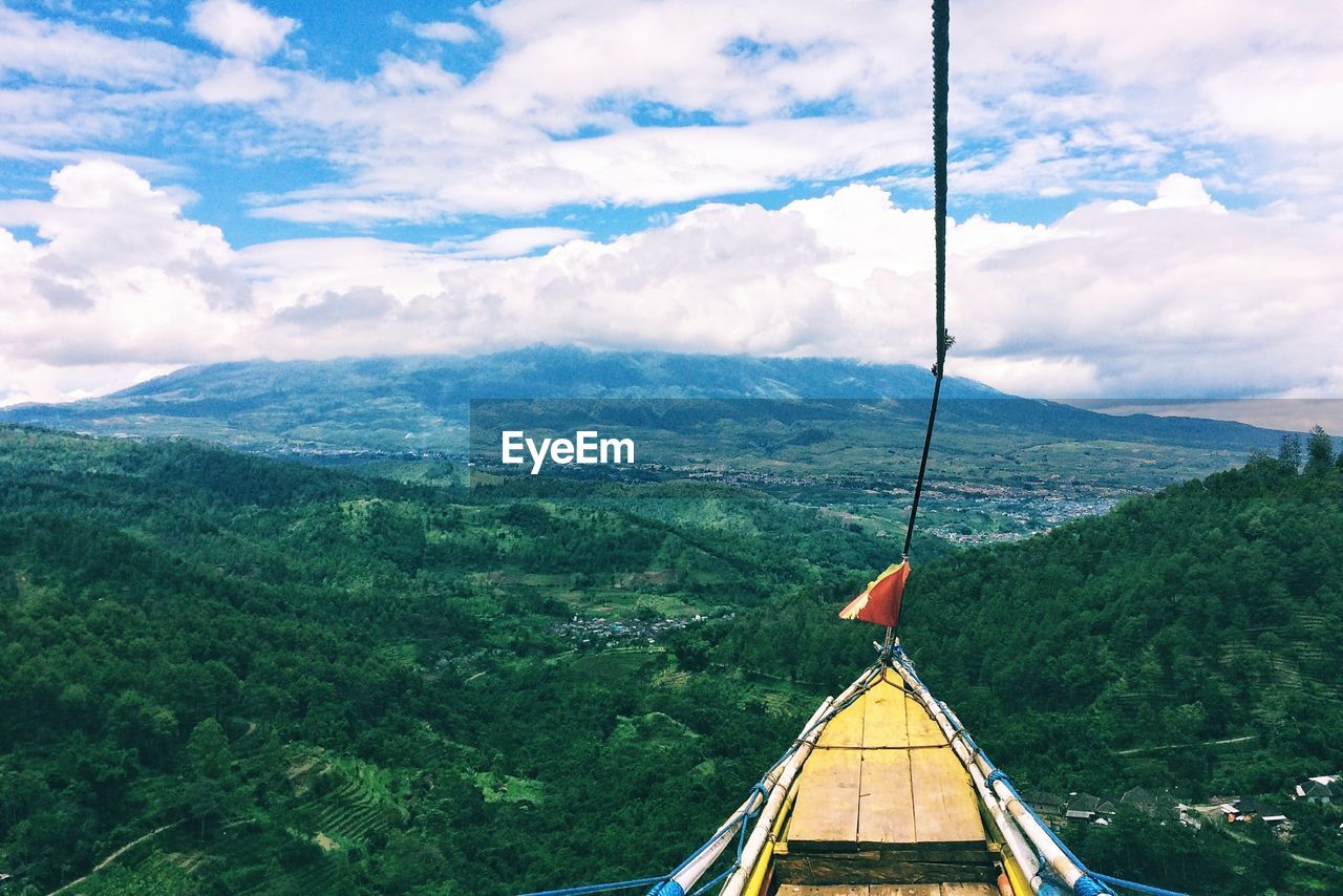 Boat hanging over landscape against sky