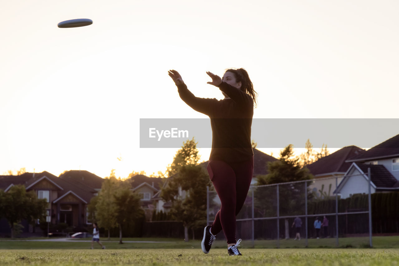 MAN PLAYING WITH BALL IN FIELD AGAINST SKY