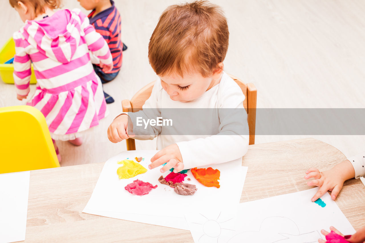 High angle view of mother and daughter sitting on table