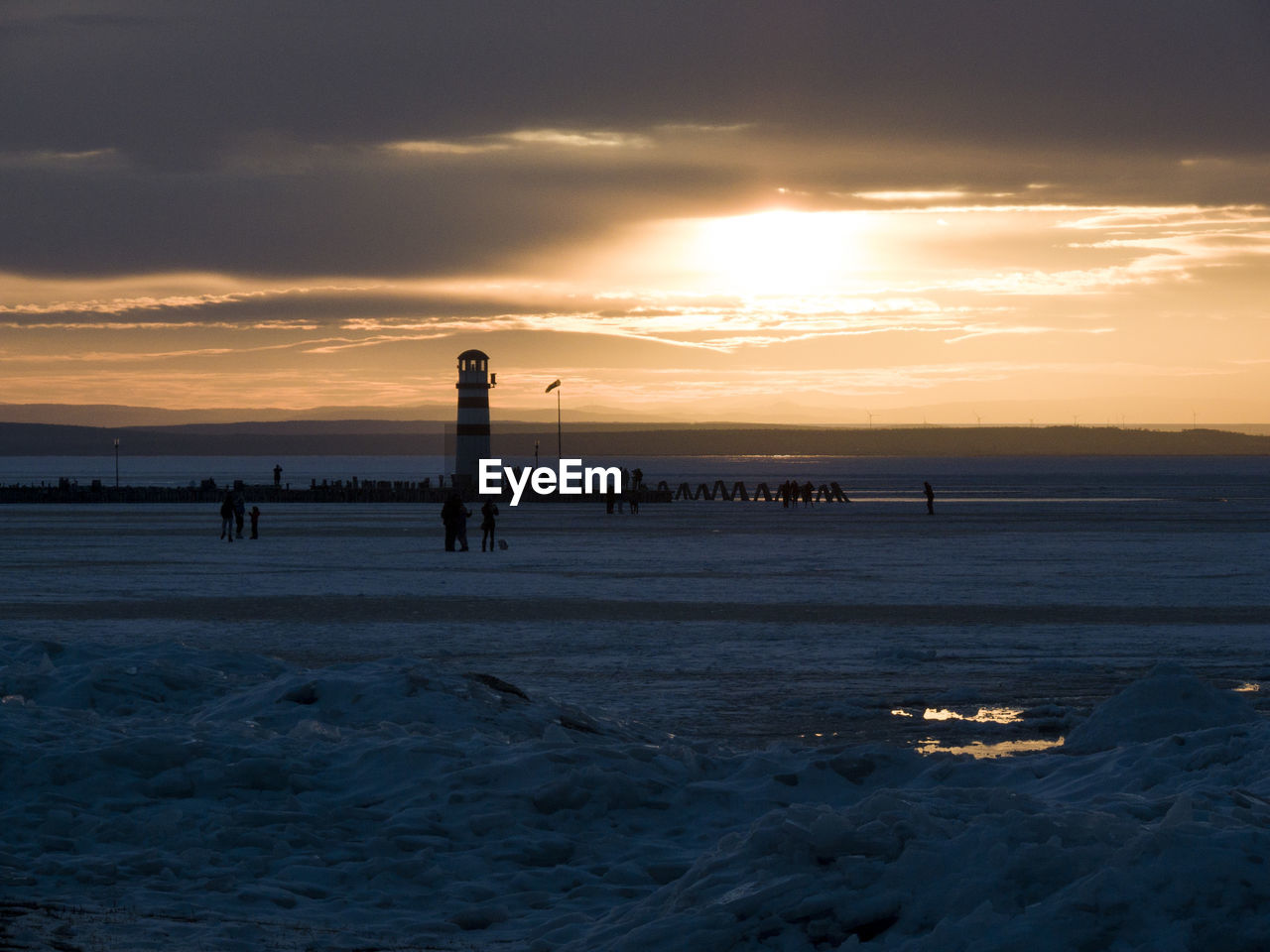 Silhouette of people in sea during winter