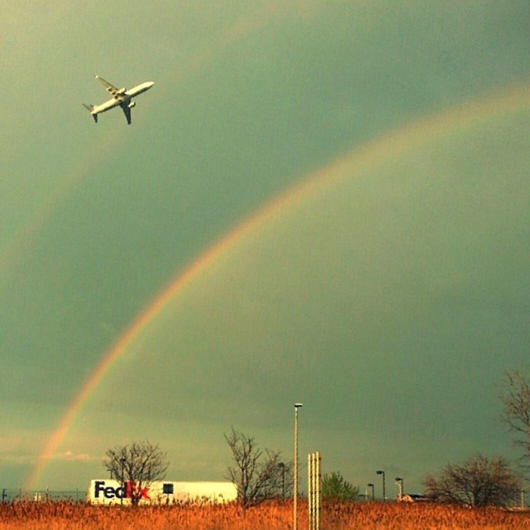 SCENIC VIEW OF RAINBOW OVER LANDSCAPE AGAINST SKY