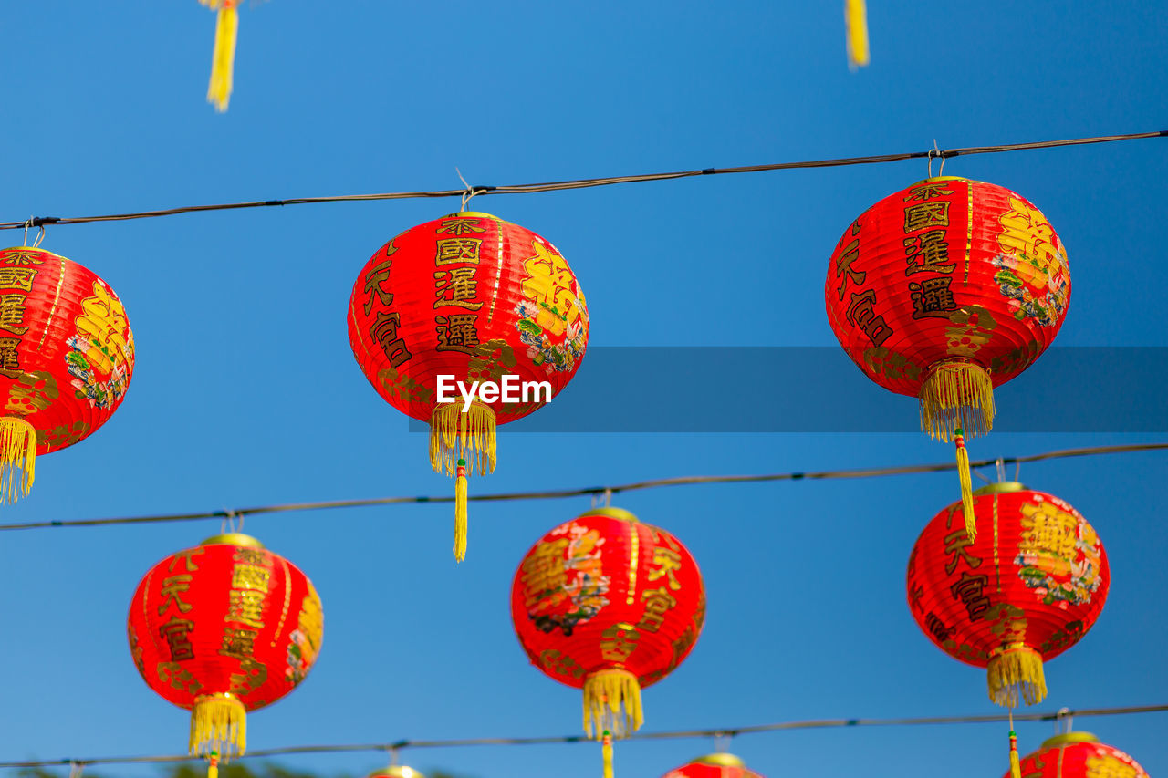 Low angle view of chinese lanterns hanging against clear sky