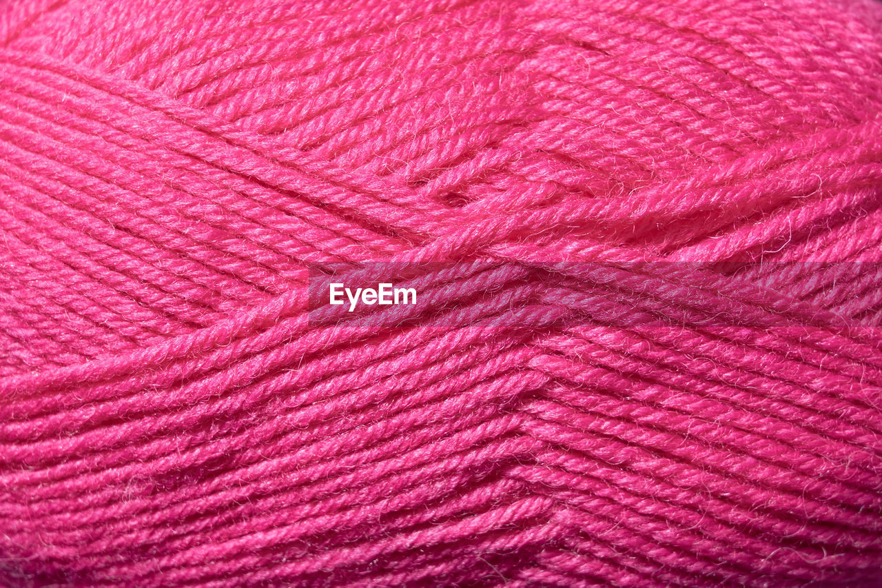 Woolly threads for knitting the color fuchsia as a background.