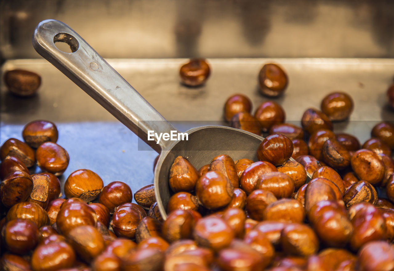 Close-up of roasted hazelnut with serving scoop on tray at market stall