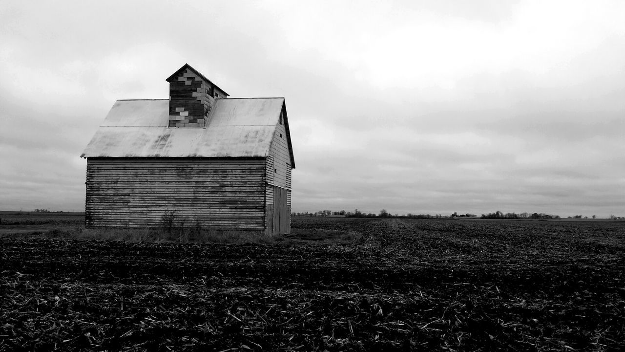 View of field against cloudy sky