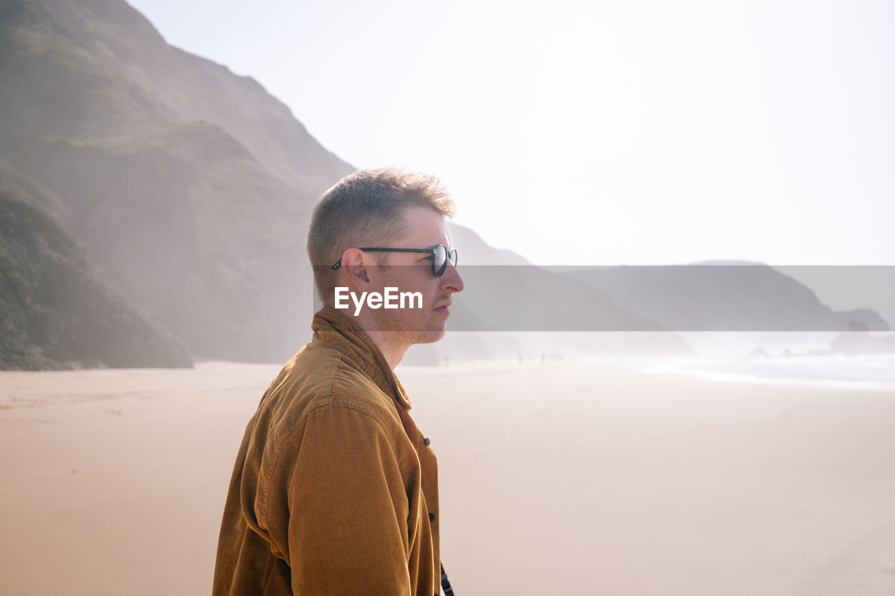 Side view of man standing against mountain