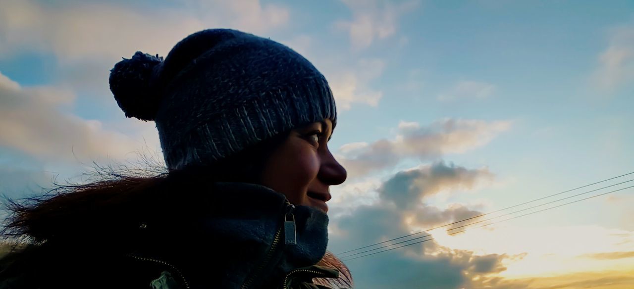 Low angle view of man against cloudy sky at dusk